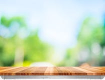 Opróżnia brown drewnianego stołowego wierzchołek z słońcem i zamazuje zielonych drzewnych bokeh półdupki obraz stock Opróżnia brown drewnianego stołowego wierzchołek z słońcem i zamazuje zielonych drzewnych bokeh półdupki obraz stock