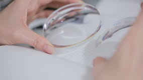 Optical round lens in female hands. inspection