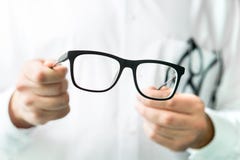 Optician holding glasses. Eye doctor showing new lenses.