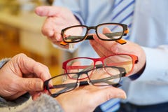 Optician offering choice of glasses stock photos Optician offering choice of glasses stock photos