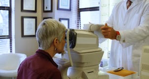 Optometrist die geduldige ogen met autorefractors 4k onderzoeken stock video Optometrist die geduldige ogen met autorefractors 4k onderzoeken stock video