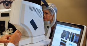 Optometrist die geduldige ogen met autorefractors 4k onderzoeken stock videobeelden Optometrist die geduldige ogen met autorefractors 4k onderzoeken stock videobeelden
