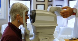 Optometrist die geduldige ogen met autorefractors 4k onderzoeken stock video Optometrist die geduldige ogen met autorefractors 4k onderzoeken stock video