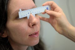 Optometrist οφθαλμολόγων οπτικός που κάνει τις μετρήσεις ματιών για έναν αρκετά νέο ασθενή γυναικών στοκ εικόνες με δικαίωμα ελεύθερης χρήσης Optometrist οφθαλμολόγων οπτικός που κάνει τις μετρήσεις ματιών για έναν αρκετά νέο ασθενή γυναικών στοκ εικόνες με δικαίωμα ελεύθερης χρήσης