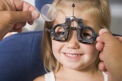 Optométriste dans la chambre d'examen avec la jeune fille photographie stock libre de droits Optométriste dans la chambre d'examen avec la jeune fille photographie stock libre de droits