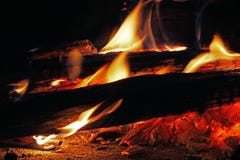 ORANGE FLAMMOR SOM HOPPAR UPP FRÅN, LOGGAR IN EN WOODFIRE arkivfoto ORANGE FLAMMOR SOM HOPPAR UPP FRÅN, LOGGAR IN EN WOODFIRE arkivfoto