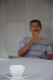 Orange fruktsaft f?r gamal mandrink f?r sunt i hans arbetsrum arkivbilder Orange fruktsaft f?r gamal mandrink f?r sunt i hans arbetsrum arkivbilder