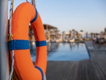 Orange lifebuoy near public swimming pool On a blurred background, a swimming pool is visible stock photos Orange lifebuoy near public swimming pool On a blurred background, a swimming pool is visible stock photos