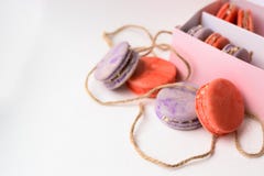 Orange purpurrote Makronen backt nahe bei der Verpackung mit Seilen zusammen lizenzfreies stockfoto Orange purpurrote Makronen backt nahe bei der Verpackung mit Seilen zusammen lizenzfreies stockfoto