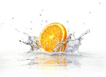 Oranje plak die en in duidelijk water valt bespat. royalty-vrije stock afbeeldingen Oranje plak die en in duidelijk water valt bespat. royalty-vrije stock afbeeldingen