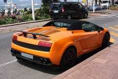Oranje supercar Lamborghini Gallardo Spyder bij de stadsstraat stock afbeelding Oranje supercar Lamborghini Gallardo Spyder bij de stadsstraat stock afbeelding