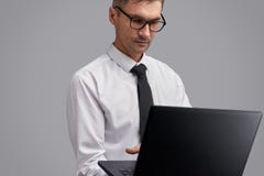 Ordenador portátil serio de la ojeada del hombre de negocios imagen de archivo libre de regalías Ordenador portátil serio de la ojeada del hombre de negocios imagen de archivo libre de regalías