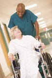 An Orderly Pushing A Senior Woman In A Wheelchair