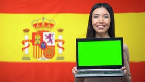 Ordinateur portable de participation d'étudiante avec l'écran vert, drapeau espagnol sur le fond banque de vidéos Ordinateur portable de participation d'étudiante avec l'écran vert, drapeau espagnol sur le fond banque de vidéos