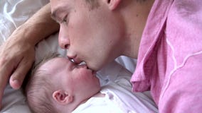 Ordre de mouvement lent de père Kissing Baby Daughter dans le lit banque de vidéos Ordre de mouvement lent de père Kissing Baby Daughter dans le lit banque de vidéos