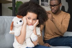 Orecchie di chiusura della ragazza africana testarda del bambino che trascurano papà nero arrabbiato fotografia stock libera da diritti Orecchie di chiusura della ragazza africana testarda del bambino che trascurano papà nero arrabbiato fotografia stock libera da diritti