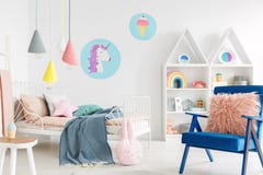 Oreiller rose velu sur un fauteuil bleu vibrant dans un bedr doux d'enfant images libres de droits Oreiller rose velu sur un fauteuil bleu vibrant dans un bedr doux d'enfant images libres de droits