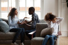 Orelhas de fechamento da filha africana virada quando pais que lutam em ho imagem de stock royalty free Orelhas de fechamento da filha africana virada quando pais que lutam em ho imagem de stock royalty free