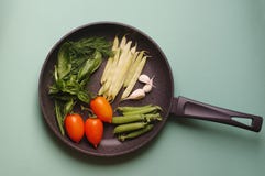 Organic fresh vegetables courgette, tomato, asparagus, basil, dill, green peas, garlic in a frying pan royalty free stock photos Organic fresh vegetables courgette, tomato, asparagus, basil, dill, green peas, garlic in a frying pan royalty free stock photos