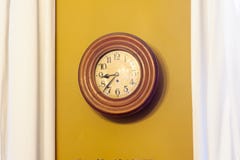 Orologio ocraceo contro la parete Fotografie Stock Libere da Diritti Orologio ocraceo contro la parete Fotografie Stock Libere da Diritti