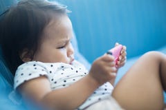 Orologio TV del bambino piccolo su uno smartphone fotografia stock libera da diritti Orologio TV del bambino piccolo su uno smartphone fotografia stock libera da diritti