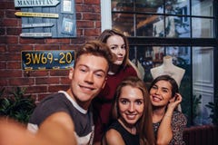 Os amigos que tomam o autorretrato fotografam, indivíduo que guarda um selfie do tiro da câmera com seus amigos fêmeas que pendur Fotografia de Stock Os amigos que tomam o autorretrato fotografam, indivíduo que guarda um selfie do tiro da câmera com seus amigos fêmeas que pendur Fotografia de Stock