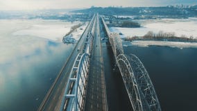 Os carros e o trem movem-se em uma ponte sobre uma metragem aérea congelada do zangão do rio vídeos de arquivo Os carros e o trem movem-se em uma ponte sobre uma metragem aérea congelada do zangão do rio vídeos de arquivo