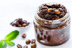 Os cosméticos caseiros com café esfregam no fundo branco da mesa foto de stock Os cosméticos caseiros com café esfregam no fundo branco da mesa foto de stock