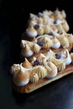 Os eclairs da torta do limão com roxo desintegram-se, ganache do citrino e merengue fotos de stock Os eclairs da torta do limão com roxo desintegram-se, ganache do citrino e merengue fotos de stock