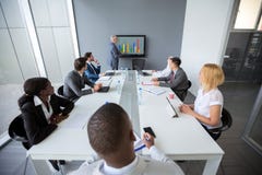 Os empregados na sala de reunião escutam diretor imagem de stock Os empregados na sala de reunião escutam diretor imagem de stock
