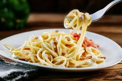 Os espaguetes italianos saborosos do carbonara rodopiaram em uma forquilha Imagens de Stock Royalty Free Os espaguetes italianos saborosos do carbonara rodopiaram em uma forquilha Imagens de Stock Royalty Free