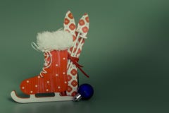 Os esquis vermelhos patinam bola azul do Natal no fundo verde Natal e ano novo imagem de stock Os esquis vermelhos patinam bola azul do Natal no fundo verde Natal e ano novo imagem de stock