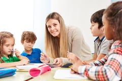 Os estudantes fazem trabalhos de casa com um professor imagem de stock Os estudantes fazem trabalhos de casa com um professor imagem de stock