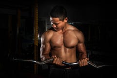 Os jovens consideráveis couberam o homem caucasiano muscular do treinamento modelo do exercício da aparência no gym que ganha o p imagens de stock Os jovens consideráveis couberam o homem caucasiano muscular do treinamento modelo do exercício da aparência no gym que ganha o p imagens de stock