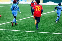 Os meninos no sportswear vermelho e azul jogam o futebol no campo de grama verde Jogo de futebol da juventude A competição de esp imagem de stock royalty free Os meninos no sportswear vermelho e azul jogam o futebol no campo de grama verde Jogo de futebol da juventude A competição de esp imagem de stock royalty free