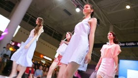 Os modelos nos vestidos andam ao longo do pódio no desfile de moda video estoque Os modelos nos vestidos andam ao longo do pódio no desfile de moda video estoque