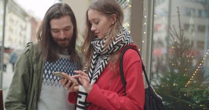 Os pares bonitos novos compartilham de memórias e de imagens em meios sociais com o móbil em linha app filme Os pares bonitos novos compartilham de memórias e de imagens em meios sociais com o móbil em linha app filme