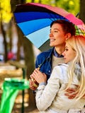 Os pares loving na data sob o outono do guarda-chuva estacionam fotografia de stock royalty free Os pares loving na data sob o outono do guarda-chuva estacionam fotografia de stock royalty free