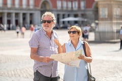 Os pares superiores perderam usando o mapa da cidade para encontrar seu lugar em Europa fotos de stock Os pares superiores perderam usando o mapa da cidade para encontrar seu lugar em Europa fotos de stock