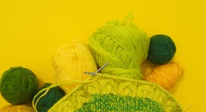 Os revestimentos amarelos e verdes das lãs encontram-se na tabela O passatempo favorito está fazendo malha fotos de stock Os revestimentos amarelos e verdes das lãs encontram-se na tabela O passatempo favorito está fazendo malha fotos de stock