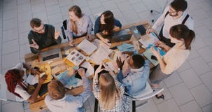Os sócios comerciais felizes cooperam na tabela moderna do escritório, criam ideias com a opinião superior do CEO masculino e video estoque Os sócios comerciais felizes cooperam na tabela moderna do escritório, criam ideias com a opinião superior do CEO masculino e video estoque