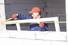 Os trabalhadores instalam a vitrifica??o em uma casa sob a constru??o fotos de stock Os trabalhadores instalam a vitrifica??o em uma casa sob a constru??o fotos de stock
