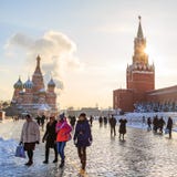 Os turistas dos países diferentes dão uma volta através do quadrado vermelho e tomam fotos na perspectiva da catedral e do th do imagens de stock Os turistas dos países diferentes dão uma volta através do quadrado vermelho e tomam fotos na perspectiva da catedral e do th do imagens de stock