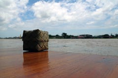 Osier thaïlandais de riz collant fait à partir de la feuille de noix de coco placée sur la table en bois, près de la rivière de C photos stock Osier thaïlandais de riz collant fait à partir de la feuille de noix de coco placée sur la table en bois, près de la rivière de C photos stock
