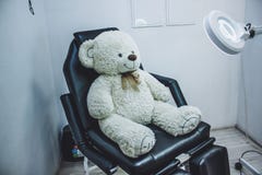Oso de peluche en la silla cosm?tica, lupa de la l?mpara para el cosmet?logo, lugar de trabajo del cosmet?logo, beauticia negro d fotografía de archivo Oso de peluche en la silla cosm?tica, lupa de la l?mpara para el cosmet?logo, lugar de trabajo del cosmet?logo, beauticia negro d fotografía de archivo