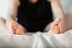 Osoba siedzi up w łóżku z ciekami w przedpolu obraz stock Osoba siedzi up w łóżku z ciekami w przedpolu obraz stock