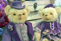 Osos de peluche en sombreros y equipos púrpuras del vintage imagenes de archivo Osos de peluche en sombreros y equipos púrpuras del vintage imagenes de archivo