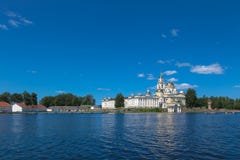 OSTASHKOV, SELIGER, RUSSIA: Monastero di Nilov sul lago Seliger Costruzione gialla Cielo blu e lago blu di estate fotografie stock libere da diritti OSTASHKOV, SELIGER, RUSSIA: Monastero di Nilov sul lago Seliger Costruzione gialla Cielo blu e lago blu di estate fotografie stock libere da diritti