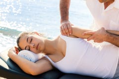 Osteopata que faz a massagem da manipulação do ombro na menina fora fotos de stock Osteopata que faz a massagem da manipulação do ombro na menina fora fotos de stock