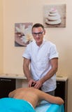 Osteopatterapeuten, gör behandligen och masserar patienten med en skada arkivfoton Osteopatterapeuten, gör behandligen och masserar patienten med en skada arkivfoton